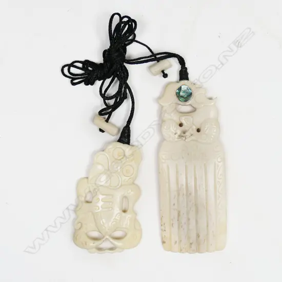 Two Paul Gyde carved bone pendants, hei tiki & heru,